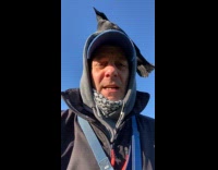 Man with his pet crow on his head 