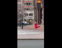 Woman in Red Dress Poses On Stairs Outside Building 