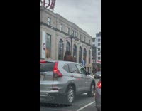 Woman in brown top peeks out on the car roof