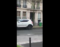 Woman walks down sidewalk and takes photos