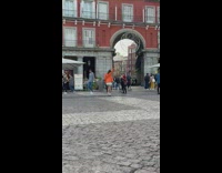 Woman in orange coat poses in the middle of park