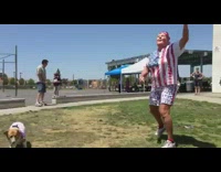 dog in white shirt bounces ball with nose