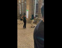 Two girls hold hands dance inside museum