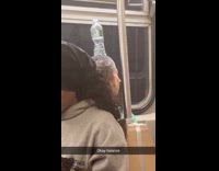 Man balances bottle on head in train
