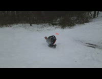 Guy rides sled over small ramp 