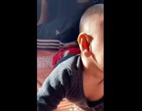 Baby boy laying on stomach smiles 