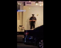 Cop stand beside taped banana on wall