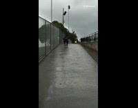 MUSIC Guy with white backpack rides scooter down wet hill black cement tokyo drift