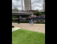 Photographer teach model pose black jacket river