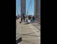 Man in black jacket hoodie sits in the middle of the bridge