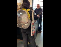 Woman inside store with bird in backpack