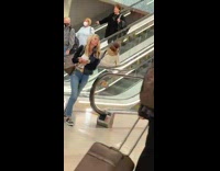Woman walks up downward escalator 
