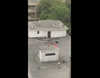 Woman white tank top red flag rooftop