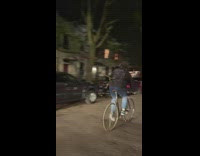 Guy rides bicycle while holding coat rack