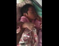 Mom records newborn baby girl and waves her arms to the beat of a song