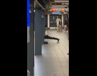 Man doing push ups on subway platform 