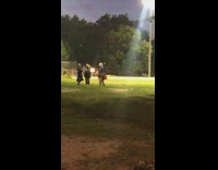 Guys in park dress up as knights with helmet, sword, and shields