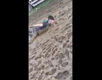 MUSIC guy green shirt pretending to swim on sand 
