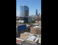 Girl swings upside down metal pole rooftop