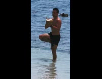 Guy poses with coconut in water 