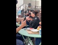 Woman eat bagel while man films her