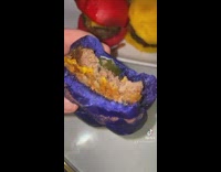 GIrl shows purple burger with different colored buns