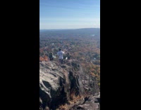 Woman on rock poses with two photographers