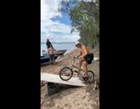 Guy rights bike up ramp into lake 