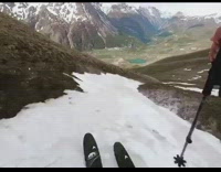 Guy rides black skis through melting snow