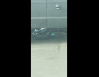 Man changes his car oil in McDonald's parking lot next to highway