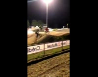 BMX biker jumps over hump, front wheel breaks off on landing, biker scorpions on dirt racetrack