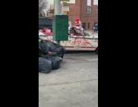 Santa Claus driving white convertible car waves 