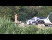 Guy takes picture of woman standing on rock 