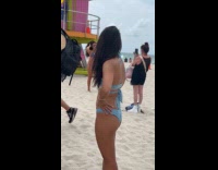 Woman bikini poses front of lifeguard house