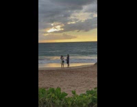 Man blue shirt roses necklace beach sunset