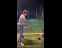 Man playing golf hits ball goes over fence