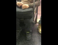 Guy holds bird in hand and pets its head on subway train