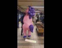 Person in pink purple inflatable unicorn costume