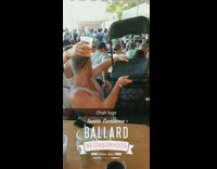 Guy in red tank top does beer luge off of a plastic black chair