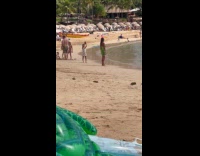 Kid takes picture of woman at beach