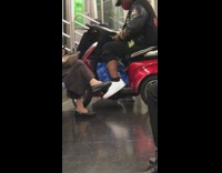 Guy sits red scooter subway white shoes