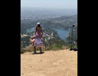 Woman sits on the shoulder of the man and raises hand