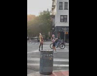 Woman black bikini pours water on her head on the street