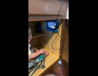 baby sitting inside of kitchen cabinet watching ipad