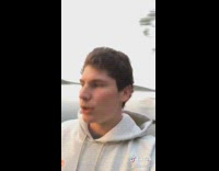 White sweater guy sits by lake sunset