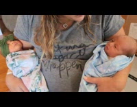 Twin baby with hiccups carried by woman