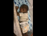 Baby laying on stomach in crib dances 