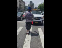 Clown blue hat juggle club on pedestrian crossing
