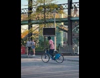 Man balances tv on his head while on the bike