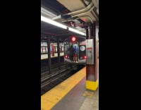 Two hitchhikers hang onto back of subway 
